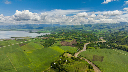 Aerial view of island coastline with farmland and town. Negros, Philippines.