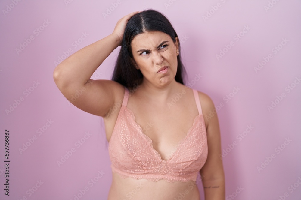 Sticker young hispanic woman wearing pink bra confuse and wondering about question. uncertain with doubt, th