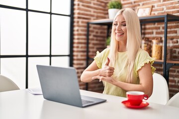 Young blonde woman having video call using deaf language at home