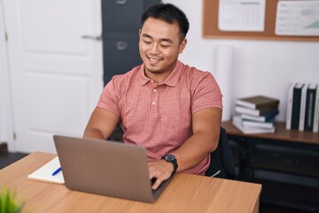 Young chinese man business worker using laptop working at office