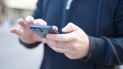 Young chinese man using smartphone at street