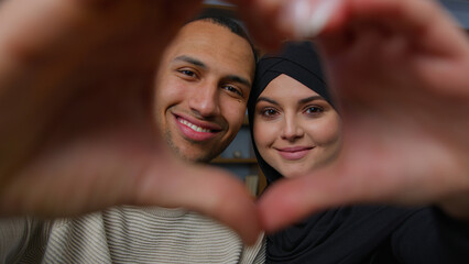 Newlyweds diverse ethnic married couple african american man with beloved arabian woman looking at camera through heart frame united husband wife hands in love shape Valentines Day romantic relation