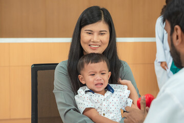 pediatrician hold stethoscope exam child boy patient with mother, black pediatrician seduce by toy kid pediatric checkup in hospital children medical care