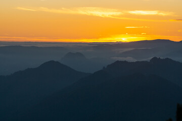 Sunset mountain fog landscape background in Cozia National Park in autumn that inspires calm and peace