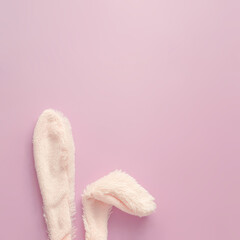 Happy Easter minimal concept. Fluffy Bunny rabbit ears on pastel pink background with copy space. Flat lay.