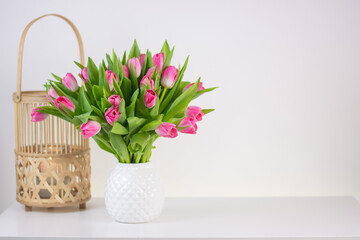 decorative lamp. vintage handmade wicker rattan lantern isolated and vase with spring flowers on white background