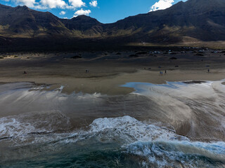 Aerial view on difficult to access golden sandy Cofete beach hidden behind mountain range on Fuerteventura, Canary islands, Spain