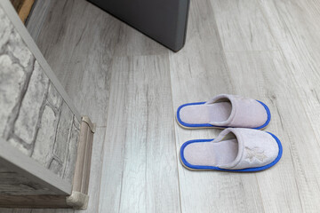 Home slippers stand near the threshold of the house.