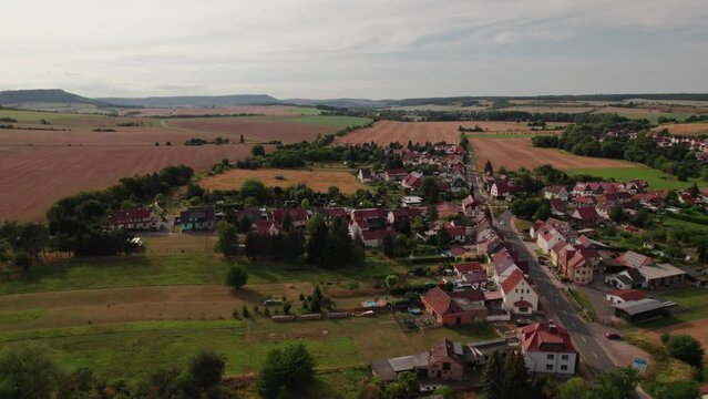Aer ial view of a German village surrounded by meadows, farmland and forest in Germany.