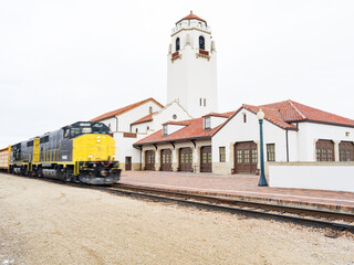 Fototapeta na wymiar Yellow and black train speeds by Depot in Boise Idaho