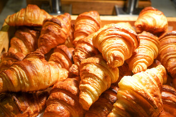 Croisants and cinnamon rolld in a display shelf.