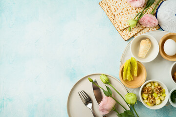 Jewish holiday Passover festive table setting with matzah, seder plate and spring flowers on blue ...