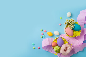Easter holiday party concept with easter eggs and gift boxes on blue background. Top view, flat lay
