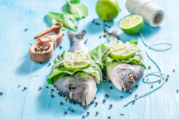 Preparing sea bream with pepper and salt on blue table