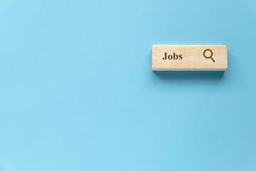 Searching for a new job, employment, a career, a job opportunity, or a work position concept. Wooden search bar isolated on a blue background with copy space.