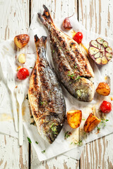Roasted seabream with potatoes, herbs and tomatoes