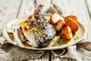 Roasted potatoes and sea bream with cherry tomatoes and thyme