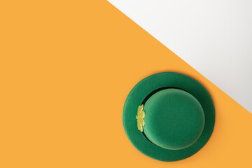 saint patrick day, green irish leprechaun hat with gold clover on orange and white background, copy...