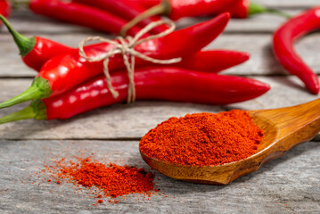Milled red chili pepper on wooden background
