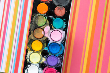 paper stripes and plastic tray with watercolor pucks