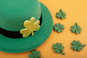 green irish leprechaun hat with shamrocks on orange background