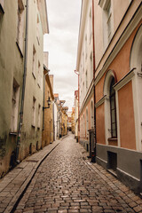 View of quaint colourful cobbled street in Tallinn old town on cloudy day in summer