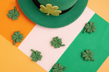 green irish leprechaun hat with shamrocks and irish flag on orange background, saint patrick day...