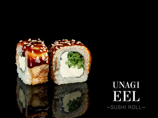 Close up to sushi roll pieces with mirror reflection on black background. Sushi roll with cream cheese, cucumber and eel, Unagi sauce on top. Ready menu advertising banner with text and copy space.