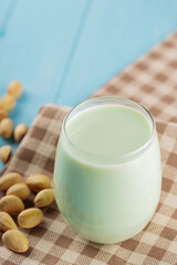 Pistachio milk in glass on blue boards. Vegan nutty plant based milk. Diet milk, vegetarian food