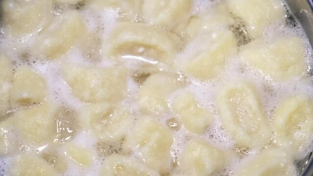 Lazy dumplings from curd dough are boiling in the pan. Top view. A traditional dish of Russian and Ukrainian cuisine. Tasty breakfast. Homemade food. Halushki.