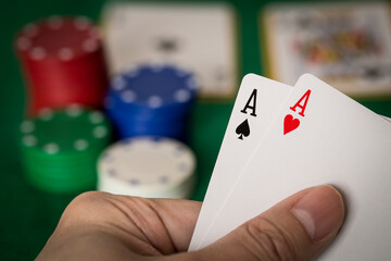Closeup of hands with two aces, Texas Hold'em Poker gambling concept