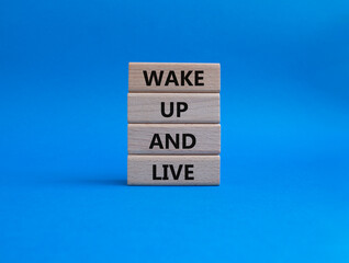 Wake up and live symbol. Wooden blocks with words Wake up and live. Beautiful blue background....