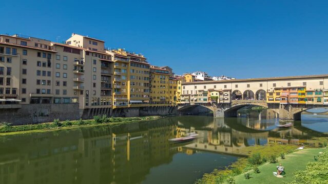 The Ponte Vecchio on a sunny day timelapse hyperlapse, a medieval stone segmental arch bridge over the Arno River, in Florence, Italy. Noted for still having shops built along it, as was once common