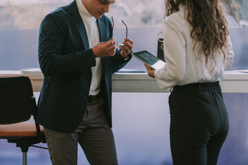 Close up of two business colleagues standing next to the window