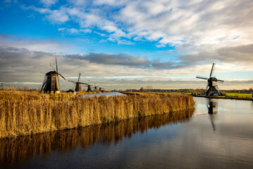 beautiful inspirational landscape with windmills in Kinderdijk, Netherlands at sunset. Fascinating places, tourist attraction. - obrazy, fototapety, plakaty