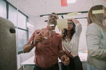 Close up of business colleagues looking at the sticky notes