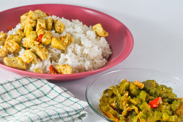 stir-fried bitter melon with sliced tempeh and white rice with sliced tofu cooked dry with chilies served in a small plate isolated on a white background