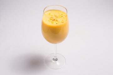 Glass full of fresh cold mango juice on a white background