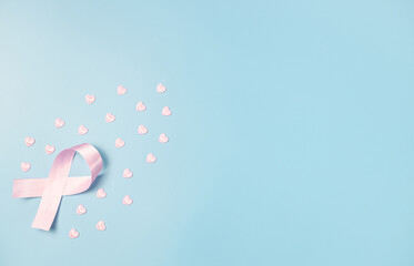 One pink ribbon with hearts on a blue background.