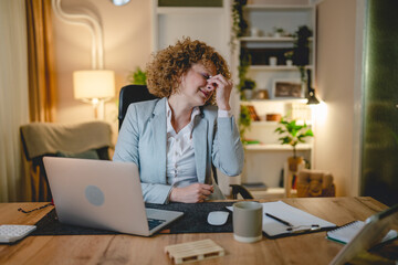 Overworked woman at work place have headache and eye strain pain