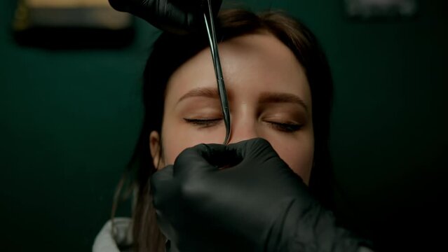 Piercing studio interior - piercing master makes piercing to girl septum nose piercing