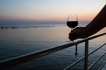 A glass of wine at seaside sunset for celebration 