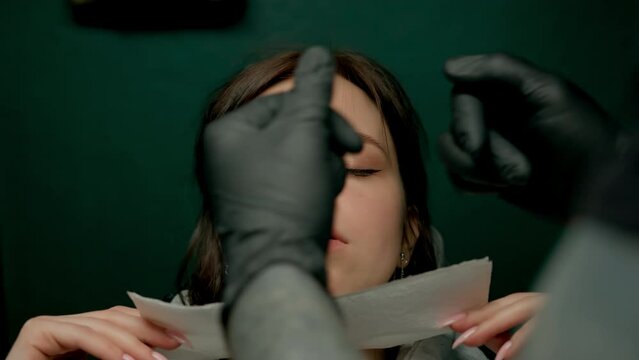 Piercing studio interior - piercing master makes piercing to girl septum nose piercing