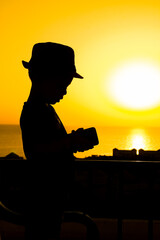Fototapeta premium Happy child in hat silhouette on sea background