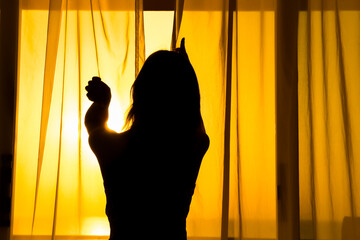 Silhouette of a girl on a loggia balcony background. Happy woman on vacation traveling.