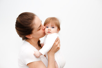 Bright portrait of happy mother holding infant child on hands. Mother hugging her little 6 months old baby. Childhood and baby care concept