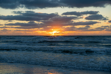 Ocean sunset landscape with soft evening sea water waves crushing on sandy beach