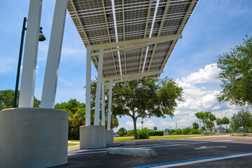 Solar panels installed over parking lot canopy shade for parked cars for effective generation of...