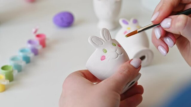 Top view on easter bunny egg holder in pastel colors. Woman preparing for spring holiday