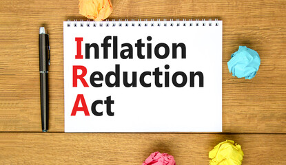 IRA inflation reduction act symbol. Concept words IRA inflation reduction act on white note on a beautiful wooden background. Business IRA inflation reduction act concept. Copy space.